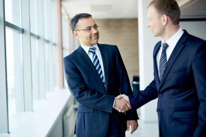 Portrait of elegant businessmen handshaking in conference hall